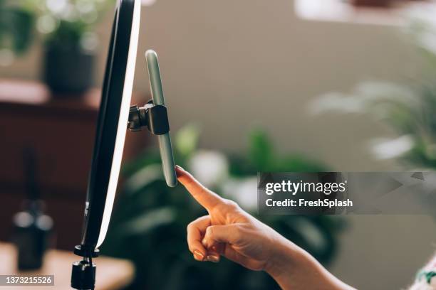 anonyme frau, die mit einem freund in einem videoanruf spricht, mit einem videoanruf-smartphone-ständer mit ringlicht - zeigefinger ring stock-fotos und bilder