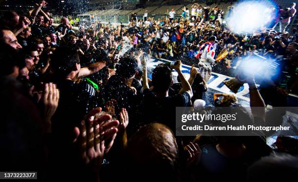 Wearing his fire protection suit racing driver overalls while draped in a Union Jack flag and holding the race winners trophy, British Mercedes-AMG...