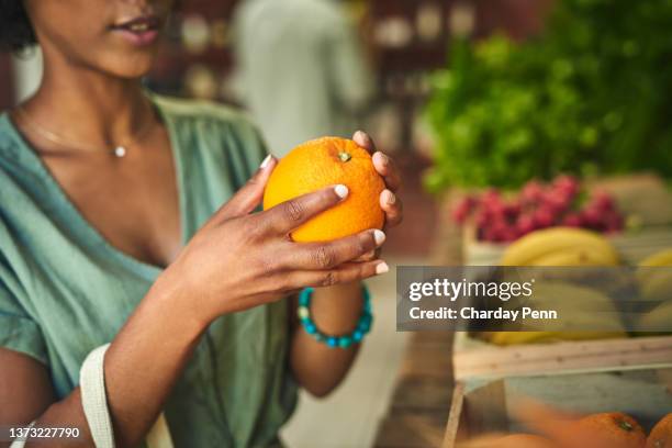 shot of a young woman shopping for fresh produce at a farmer’s market - african market stock pictures, royalty-free photos & images