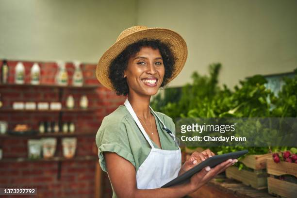 shot of a young woman using a digital tablet while working at a farmer’s market - farm woman bildbanksfoton och bilder