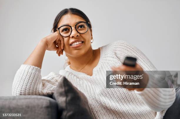 shot of a young woman watching tv on the sofa at home - serviço de distribuição digital contínua imagens e fotografias de stock