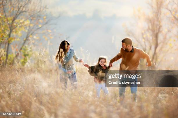 happy family having fun while running through tall grass in autumn day. - timothy grass imagens e fotografias de stock