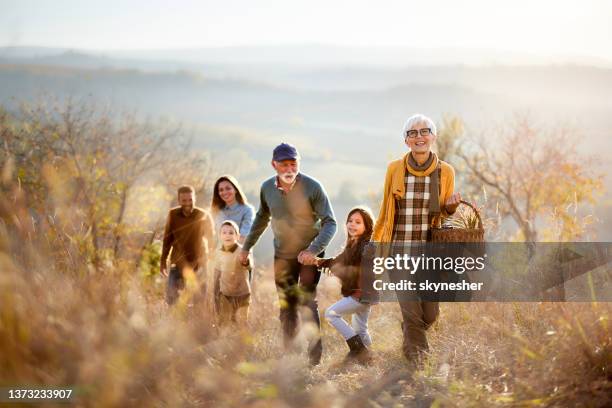 happy multi-generation family going on a picnic in autumn day. - multi generation family walking stock pictures, royalty-free photos & images