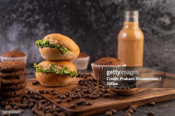 burger with wooden cutting board,including cupcakes and coffee beans - süßgebäck teilchen stock-fotos und bilder