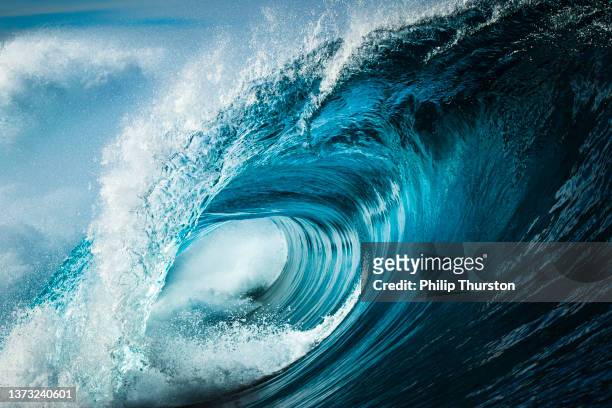 détail en gros plan d’une puissante vague bleu sarcelle se brisant en pleine mer par un après-midi ensoleillé - mer photos et images de collection