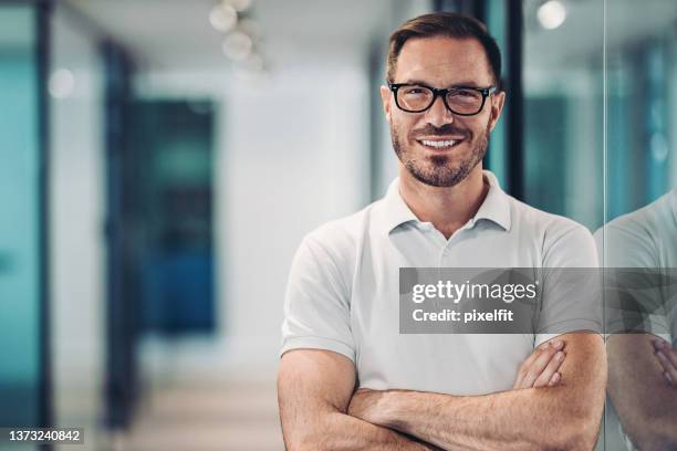 lächelnder mittlerer erwachsener im poloshirt - business man portrait smiling stock-fotos und bilder