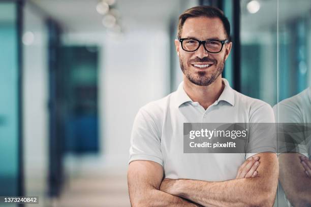 smiling mid adult man in polo shirt - camisa pólo imagens e fotografias de stock