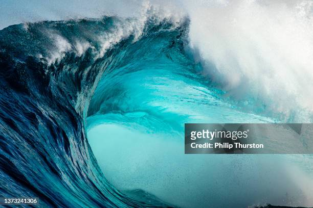 dettaglio ravvicinato estremo della potente onda blu verde acqua che si infrange selvaggiamente su una barriera corallina - giant foto e immagini stock