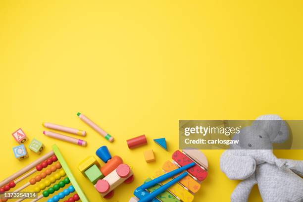 assortment of toddler toys with copy space on yellow background - dagis bildbanksfoton och bilder