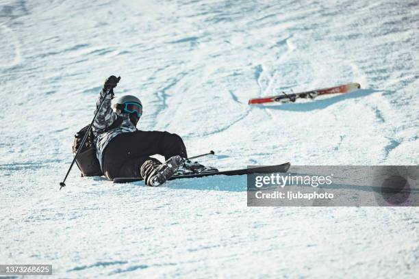 injured skier lying in the snow after accident. - skipiste stockfoto's en -beelden