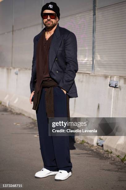 Alex Badia poses ahead of the Marni fashion show wearing a brown shirt, blue blazer, blue pants and black hat during the Milan Fashion Week...
