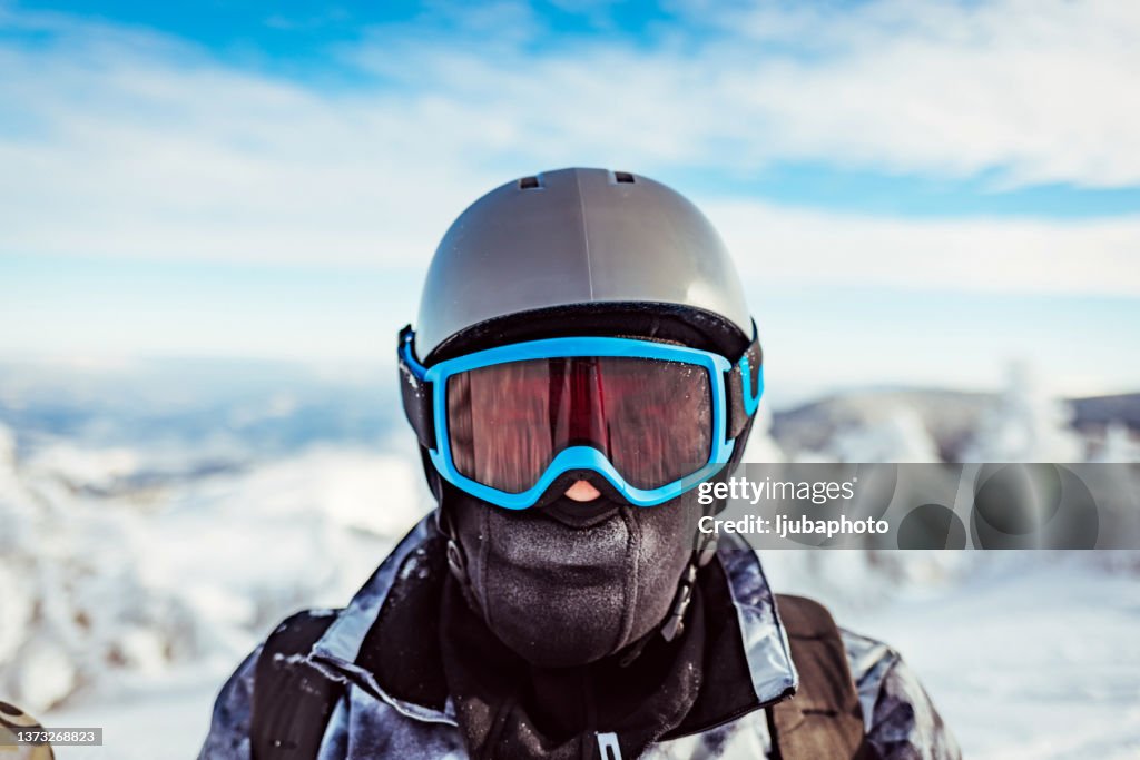 Uno sciatore da vicino su un pendio innevato di montagna