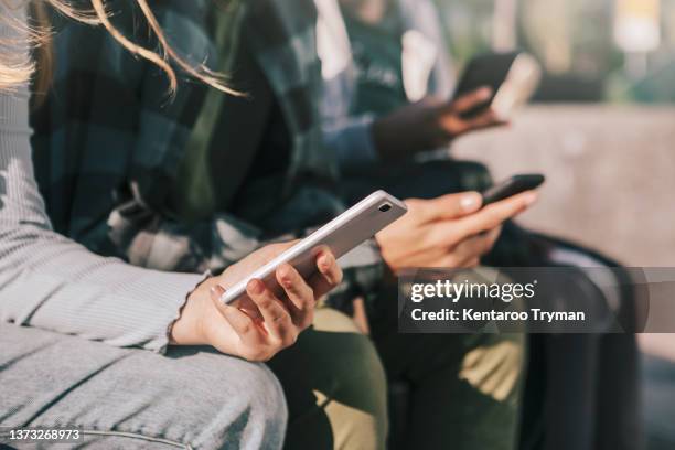 detail of teenagers watching with their mobile phones - fille 14 ans photos et images de collection