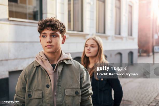 two teenagers standing in back light in city environment - casal adolescente imagens e fotografias de stock