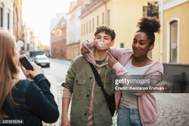 three teenagers friends having fun with taking photos on bubble gum - bubble gum stockfoto's en -beelden