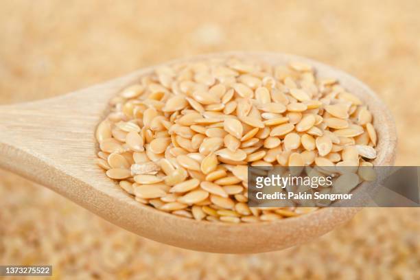 golden flax seeds in a wooden spoon on a wooden table background. - ビタミンb3 ストックフォトと画像