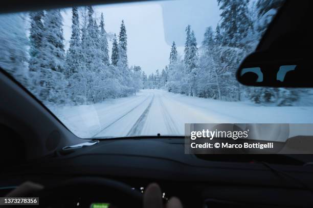 personal perspecive of person driving on snowy road in lapland - finse cultuur stockfoto's en -beelden