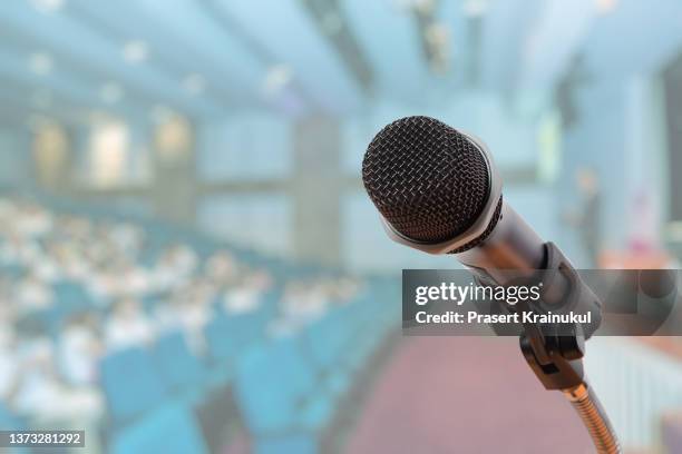 microphone in conference hall or seminar room with attendee background. - colour microphone stock-fotos und bilder