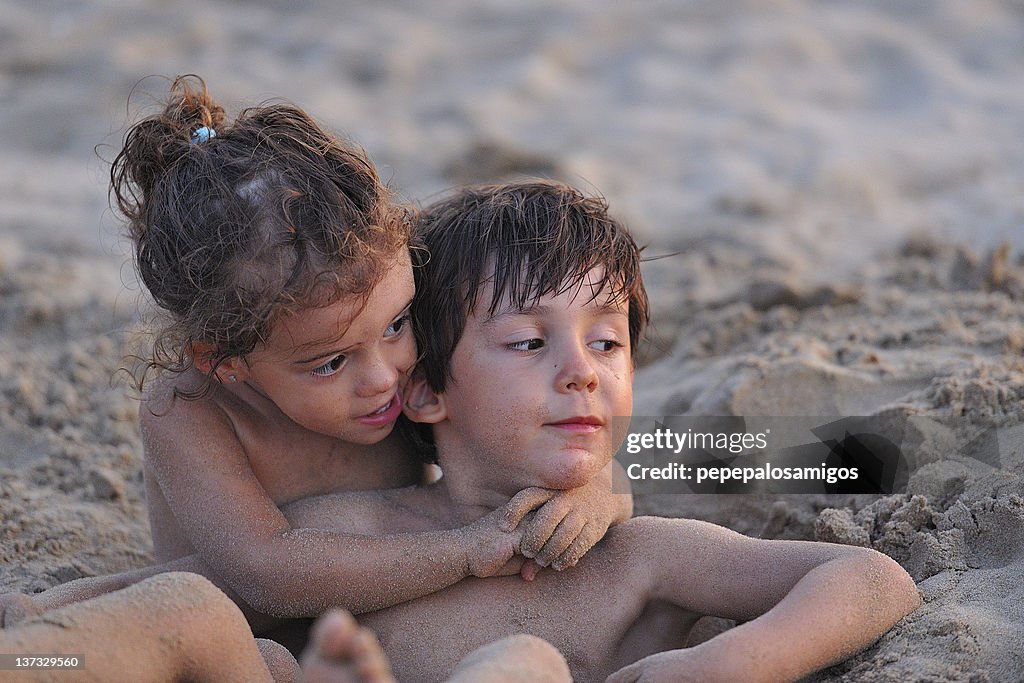 Boy and girl playing in sand, Spain