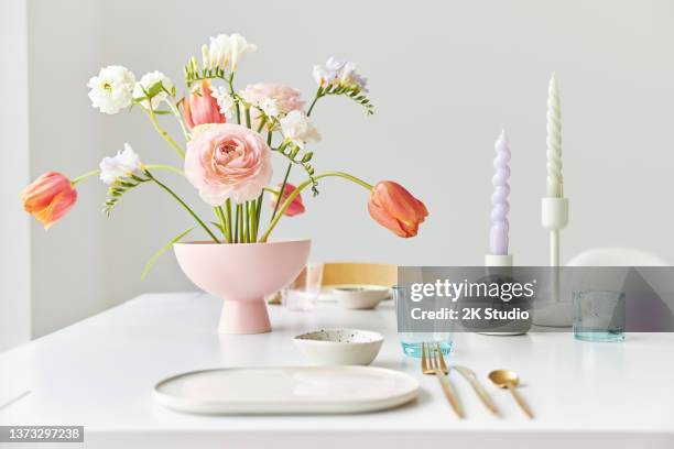 un moderno ramo de primavera con fresias, ranúnculos y tulipanes en un hermoso jarrón - cubierto completo fotografías e imágenes de stock