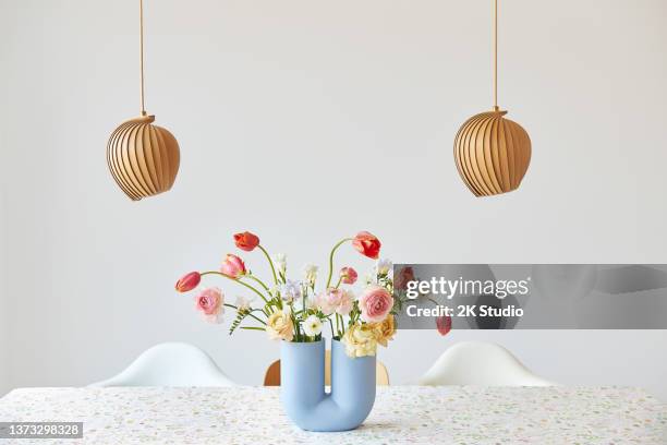 ein moderner frühlingsstrauß aus freesien, ranunkeln und tulpen in einer schönen vase - blumen als accessoire stock-fotos und bilder