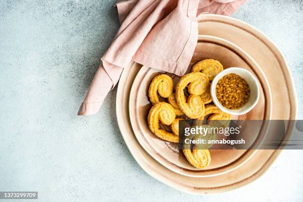 overhead view of a bowl of palmier biscuits with brown sugar - foodstyling stock-fotos und bilder