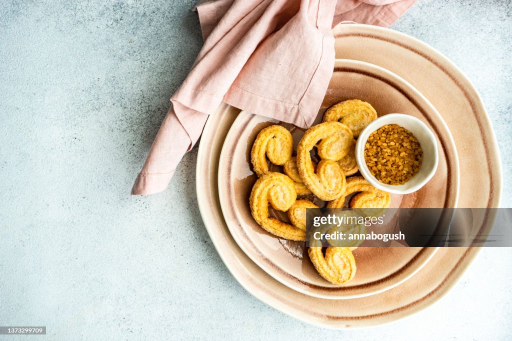 Overhead view of a bowl of palmier biscuits with brown sugar