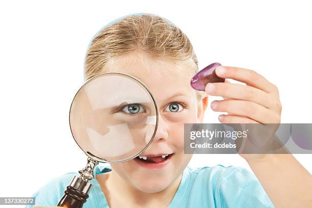 girl looking through magnifying glass at minerals - gap closers stock pictures, royalty-free photos & images