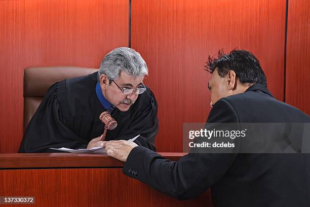 lawyer speaking with judge in courtroom - judge bench stock pictures, royalty-free photos & images