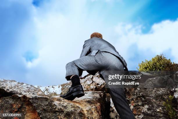 reaching the top: rear view of businessman in a suit climbing to the summit of a mountain - buttock photos 個照片及圖片檔