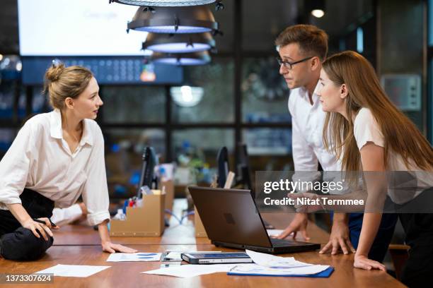 reviews business plan and innovation tool for fintech ( financial technology ) startup solutions. female chief software developer having a meeting with business team to review financial business process in a financial service business office - financial analyst photos et images de collection