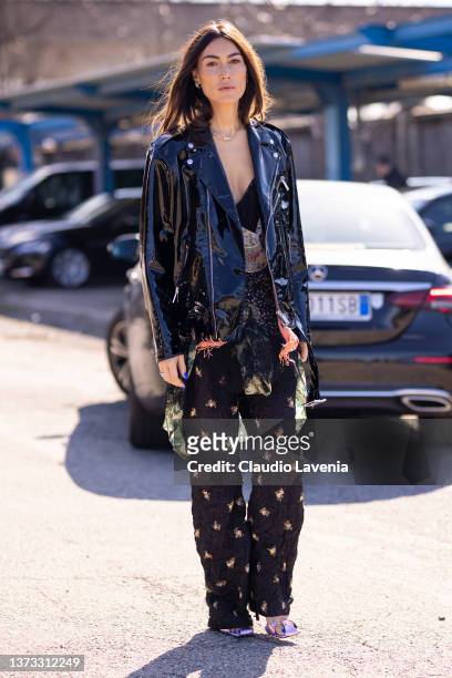 Giorgia Tordini poses ahead of the DSQUARED2 fashion show wearing a printed top, black flower printed pants, black vinyl jacket during the Milan...