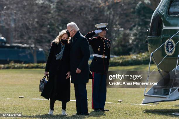 President Joe Biden kisses first lady Jill Biden as they walk off Marine One on the South Lawn of the White House after returning from Delaware on...