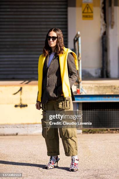 Erika Boldrin poses ahead of the DSQUARED2 fashion show wearing a brown blazer, olive green cargo pants, yellow jumper and decorated heels during the...