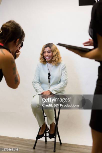 female television host smiles as photographer takes headshots - photo shoot studio bildbanksfoton och bilder