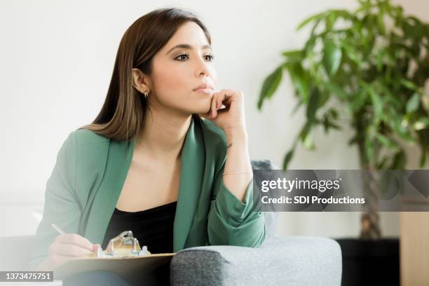 woman sits in office to come up with a business plan - thinking stock pictures, royalty-free photos & images
