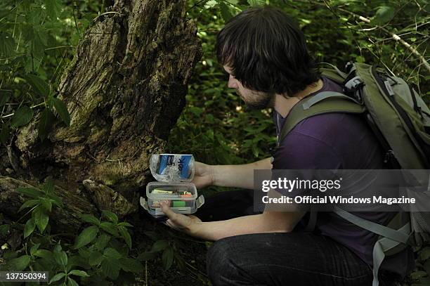 Man discovering a geocache in a lush forest while geocaching on July 5 Monkton Farleigh.