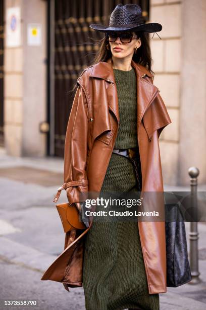 Katya Tolstova poses ahead of the Giorgio Armani fashion show wearing olive green sweater maxi dress, brown leather belt, brown leather trench coat,...