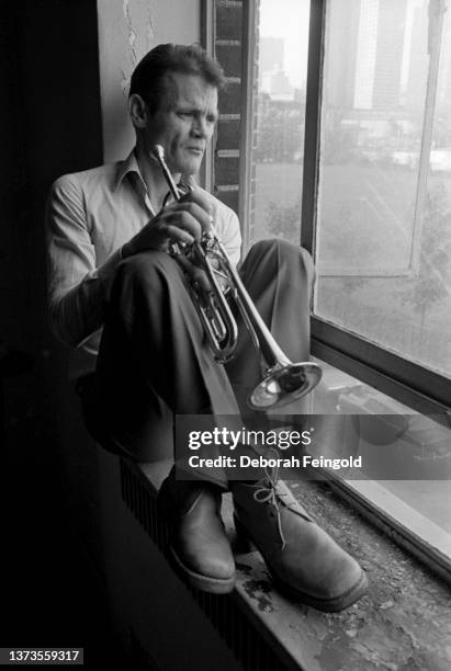 Deborah Feingold/Corbis via Getty Images) Portrait of American Jazz musician Chet Baker , a trumpet in his hands, as he sits on a windowsill, New...