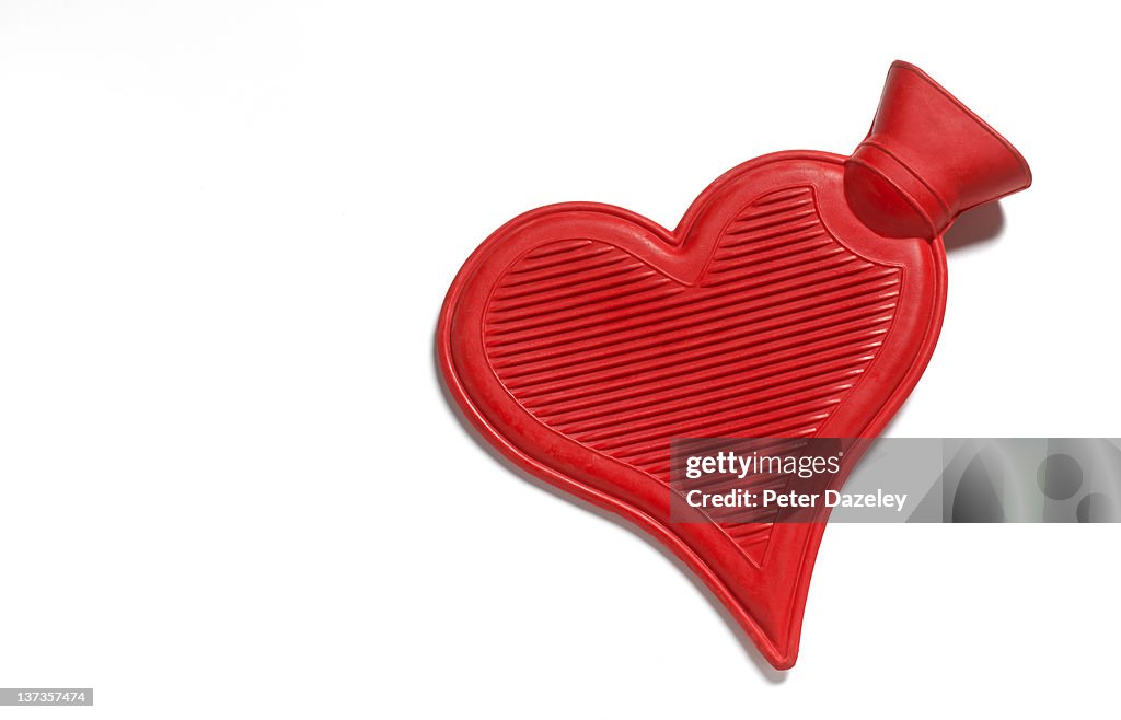 Heart shaped hot water bottle on white background