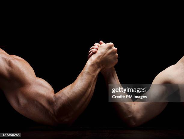 arm wrestling mismatch - echar un pulso fotografías e imágenes de stock