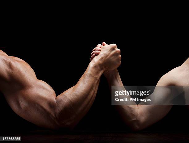 arm wrestling mismatch - muscular build stock pictures, royalty-free photos & images