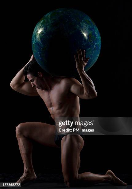 man holds marble ball on shoulders - mythologische gestalt stock-fotos und bilder