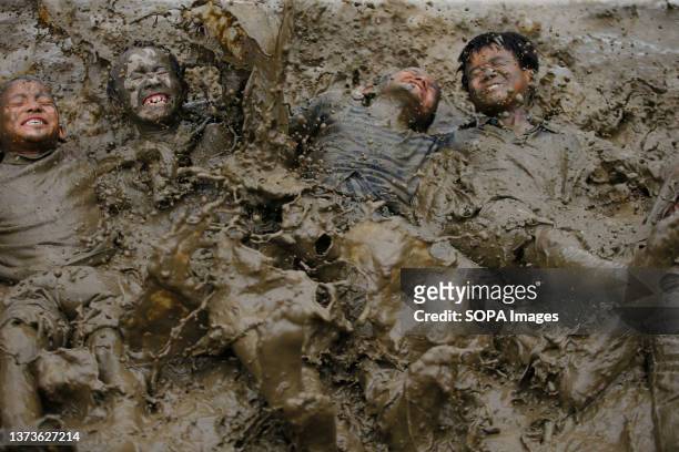 Kids play in muddy paddy fields to commemorate Asar Pandra, also known as National Paddy Day, which signifies the commencement of rice cultivation...