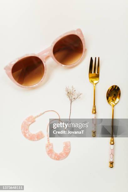 pink inspiration with sunglasses, earrings, spoon, knife and dried plant on white paper - jewellery collection stock pictures, royalty-free photos & images