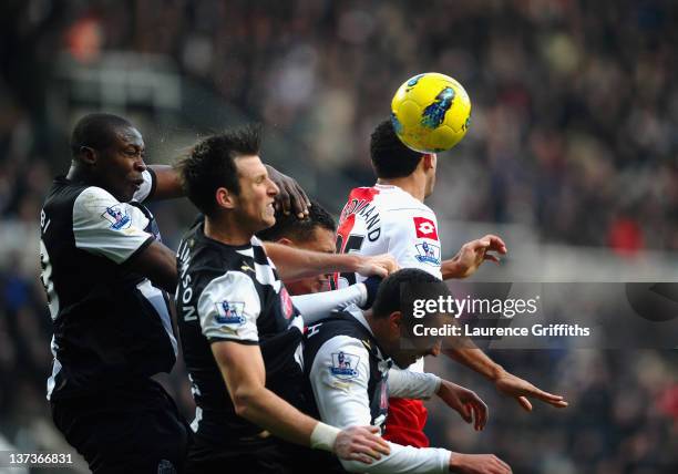 Shola Ameobi of Newcastle United clears the ball under pressure during the Barclays Premier League match between Newcastle United and Queens Park...