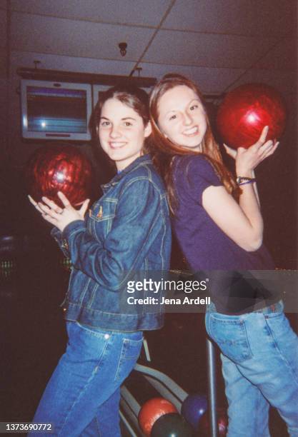 vintage candid portrait best friends back to back holding bowling balls in bowling alley - 2000 fashion stock pictures, royalty-free photos & images