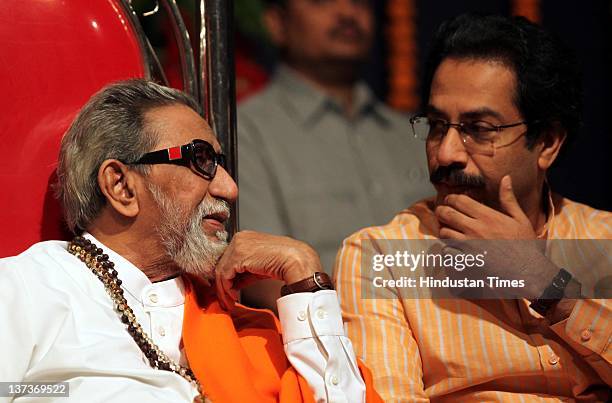 Shivsena chief Balasaheb Thackeray chats with executive president Uddhav Thackeray during the party workers meeting before upcoming civic elections...