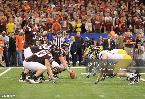 Logan Thomas of the Virginia Tech Hokies calls signals out as center Andrew Miller readies to snap the at the line of scrimmage on offense against...