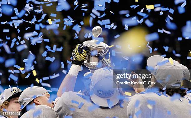 The Michigan Wolverines celebrate with the trophy after they won 23-20 i9novertime against the Virginia Tech Hokies during the Allstate Sugar Bowl at...